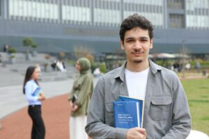 college student holding books outdoors on campus