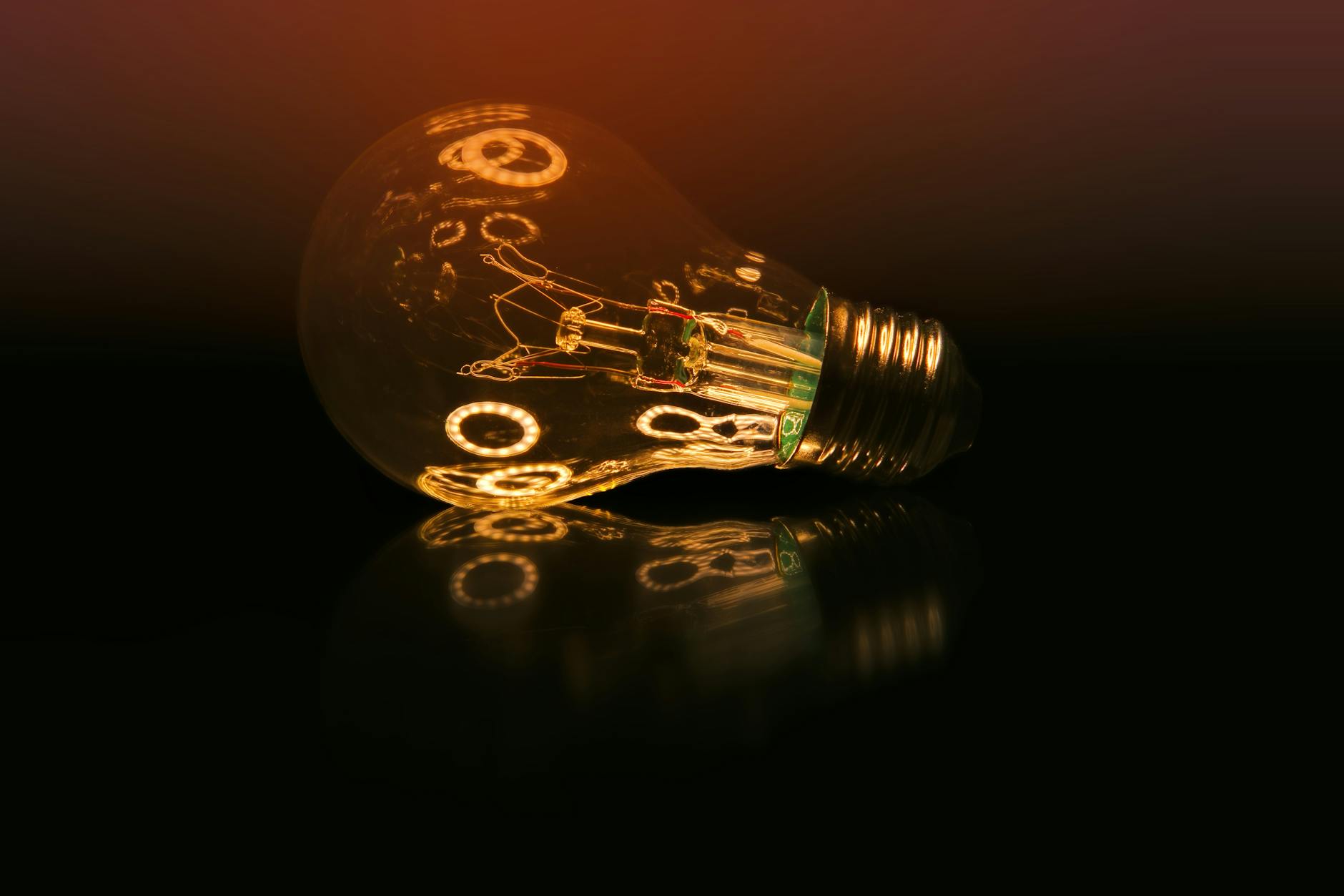 illuminated light bulb on reflective surface